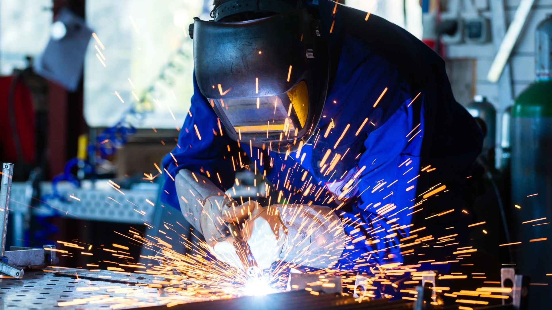 welder welding metal in workshop