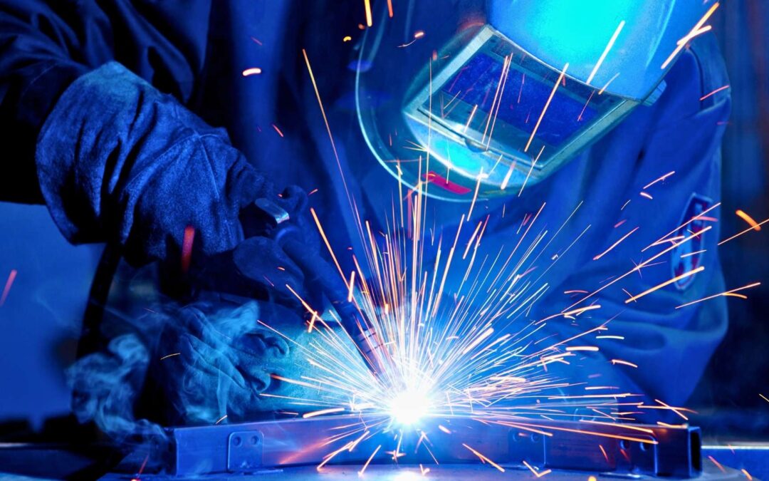structural welding services michigan welder suturing pieces of metal sheets together with mask and torch