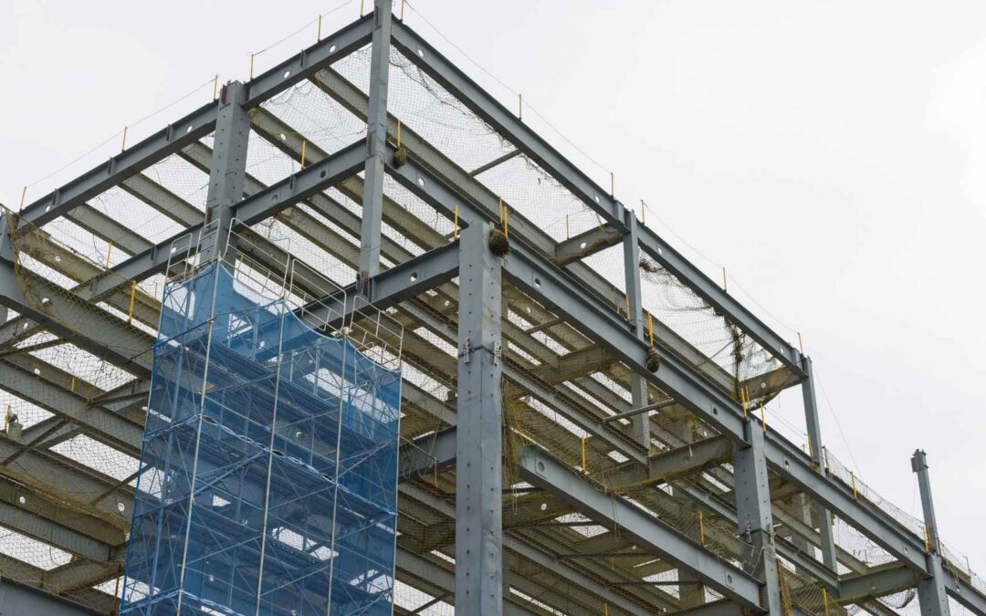Construction site of a steel structure being built with scaffolding climbing up the building